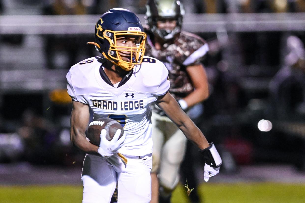 Grand Ledge's Shawn Foster runs for a gain against Holt during the first quarter on Friday, Oct. 22, 2021, at Holt High School.