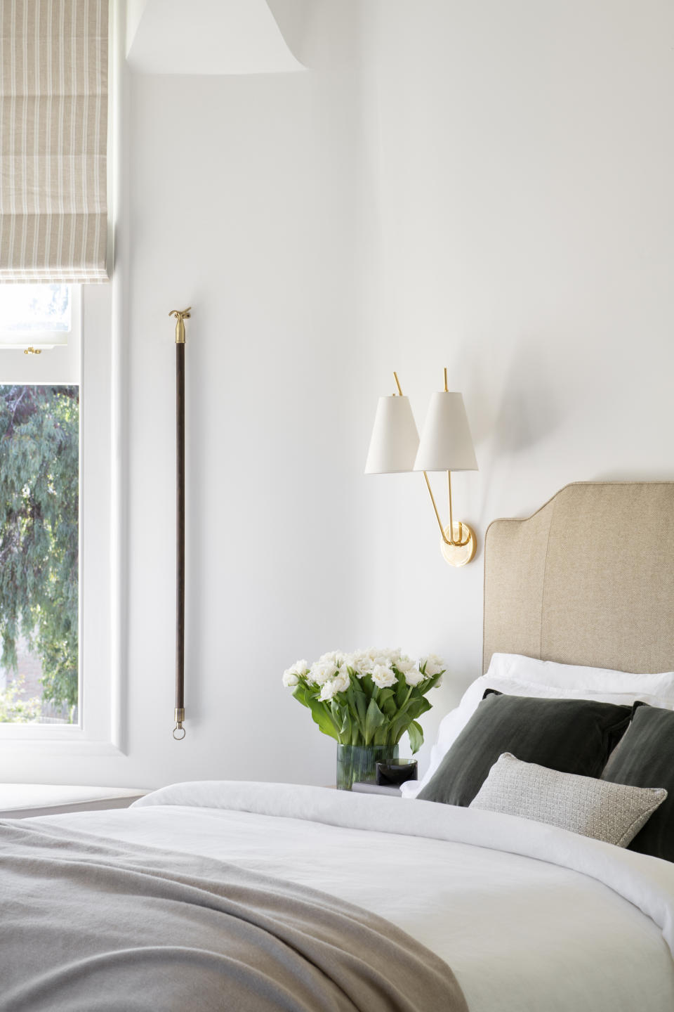 A nightstand decorated with fresh flowers and a hanging light