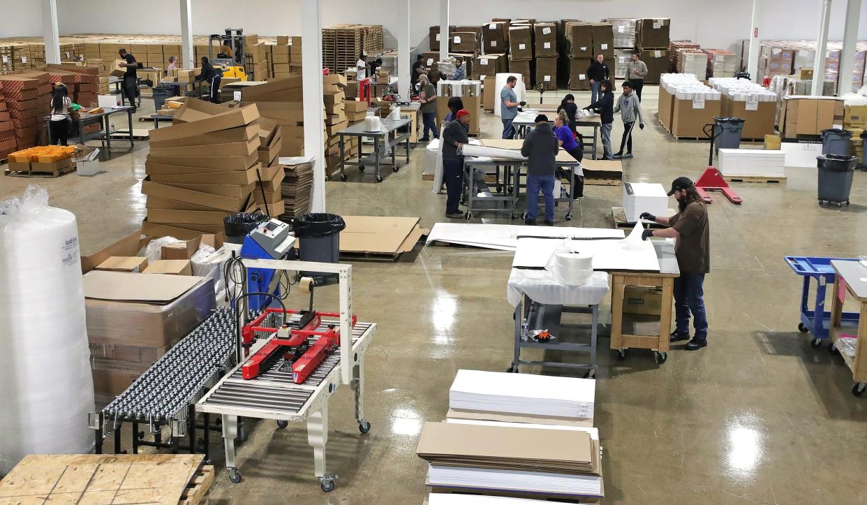 OnQ Solutions production workers fulfill orders for companies in the business' new space in the former Chapel Hill Mall in Akron.