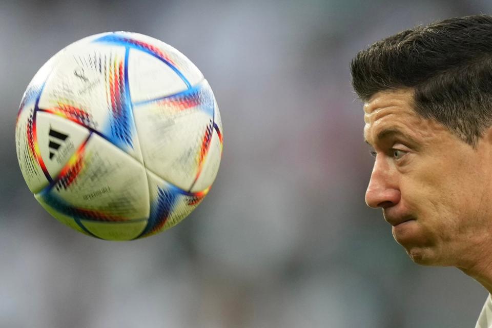 Poland's Robert Lewandowski eyes the ball as he is challenged by Saudi Arabia's Abdulelah Al-Amri during the World Cup group C football match between Poland and Saudi Arabia, at the Education City Stadium in Al Rayyan, Qatar, Saturday, Nov. 26, 2022. (AP Photo/Francisco Seco)