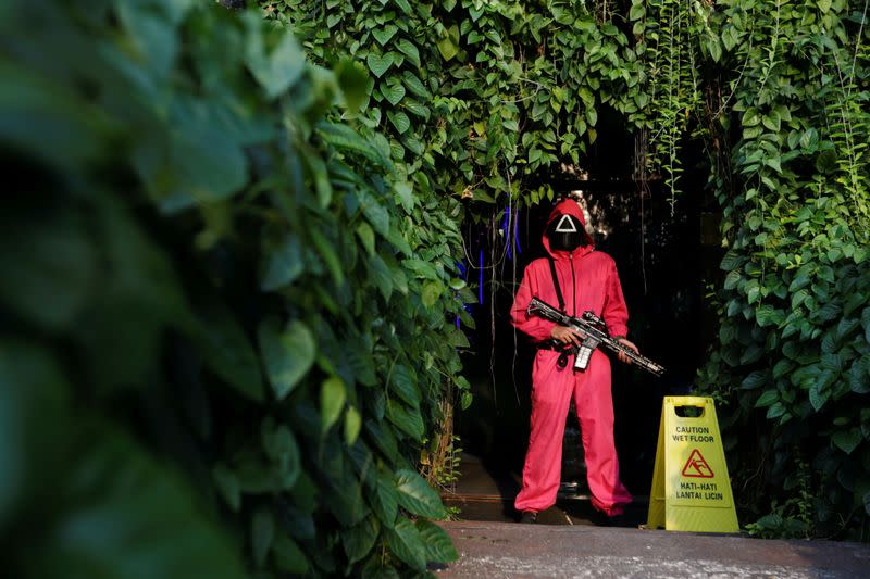 FILE PHOTO: A staff member wearing 'Squid Game' costume stands guard at Strawberry Cafe in Jakarta