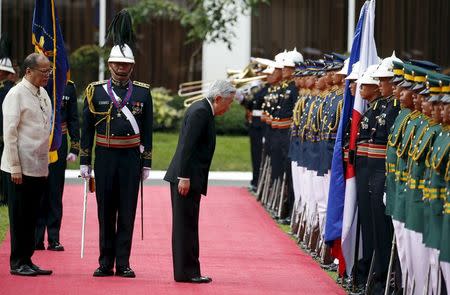 Japan's Emperor Akihito bows his head before the colors during a welcoming ceremony by President Benigno Aquino (L) at the Malacanang presidential palace in Manila January 27, 2016. REUTERS/Erik De Castro