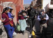 Indigenous woman Maria Cajavilca, 83, is escorted by a police officer in Huamanga, Peru, Thursday, Sept. 2, 2021. Cajavilca, who speaks only Quechua, was found lost, not remembering where she lives, and the police officer was one of the few people who understood her and could help. (AP Photo/Martin Mejia)