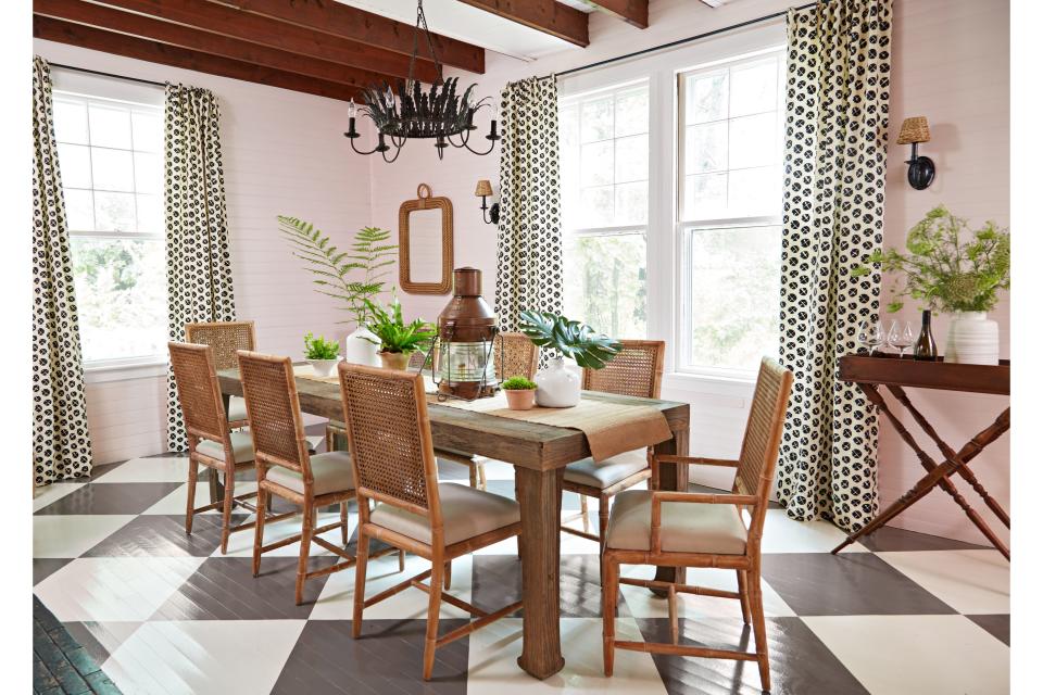 <p>Rylee softened the walls in the dining room with a blush hue and checkerboard-painted the wood floor for a playful sense of drama. Sand dollar–patterned fabric on the windows is a nod to local beach bounty.</p>