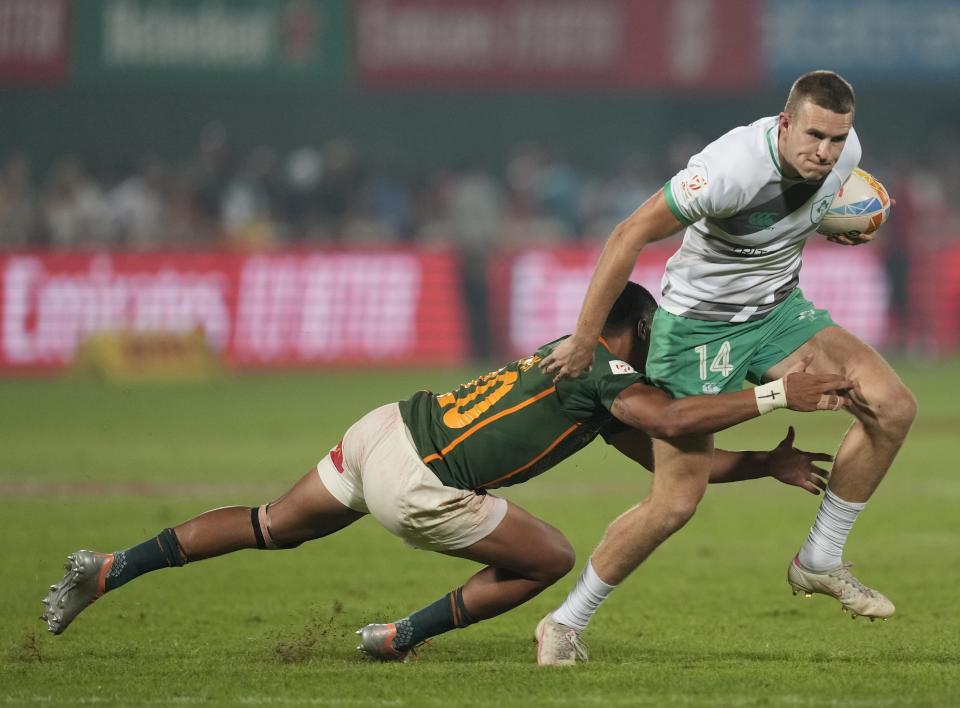 Ireland's Ed Kelly is tackled by South Africa's Shilton van Wyk during the final match of the Emirates Airline Rugby Sevens, in Dubai, United Arab Emirates, Saturday, Dec. 3, 2022. (AP Photo/Kamran Jebreili)