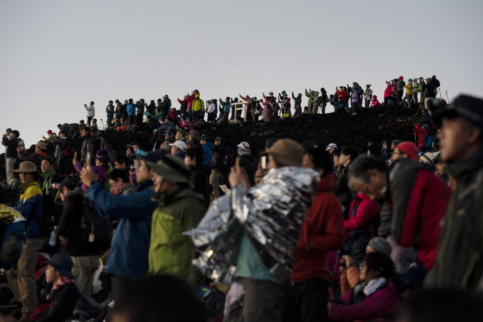 Cientos de personas disfrutan, móvil en mano, del espectáculo del amanecer desde lo alto del Fuji. <br><br>Foto: AP Photo/Jae C. Hong