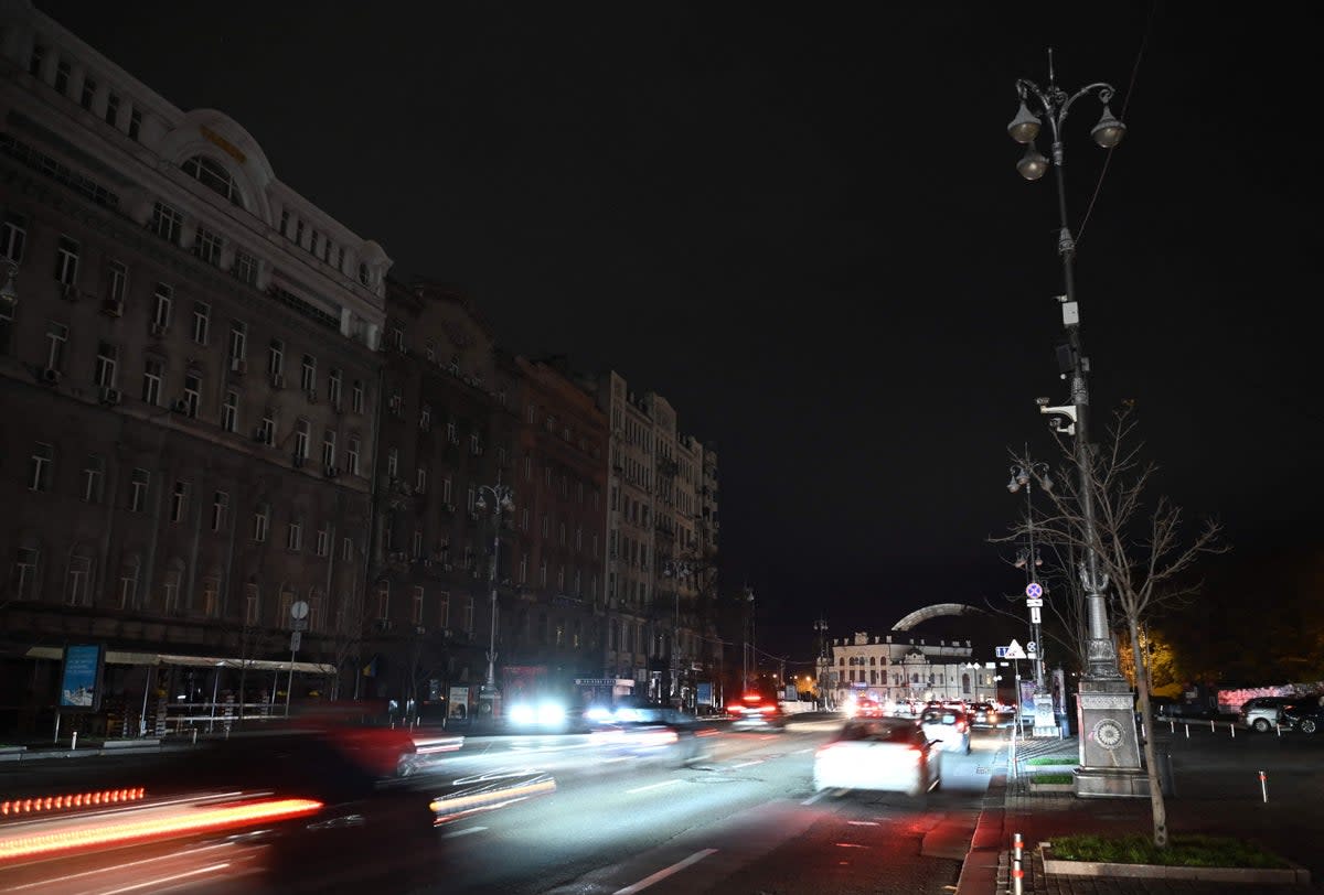 Cars ride along a darkened Khreshchatyk central street in Kyiv  (AFP via Getty Images)