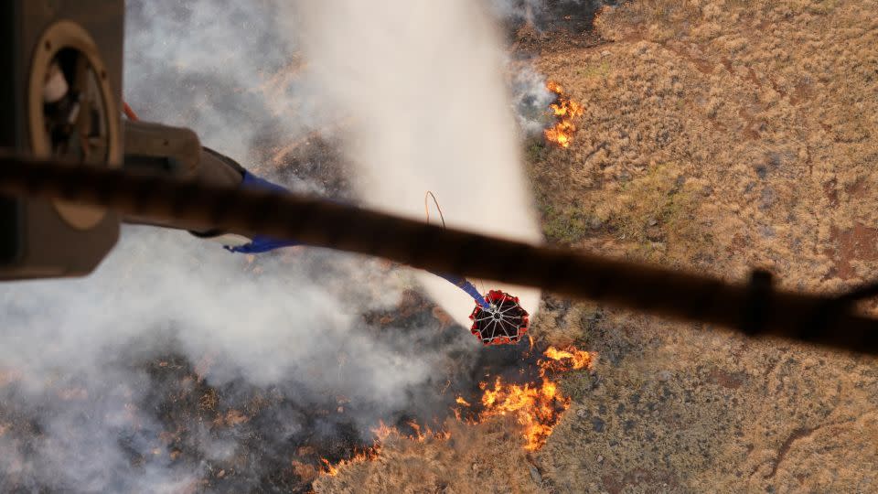 Hawaii Army National Guard CH47 Chinook helicopters perform aerial water bucket drops on the island of Maui to assist with fight of wildfires in Maui, Hawaii, August 9, 2023.  - Hawaii National Guard/Reuters