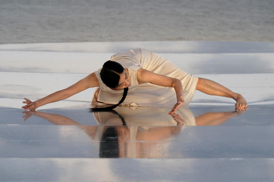 Dancer and choreographer Su Wen-Chi, of Taiwan, performs a dance titled "Moving Towards the Horizon" on the beach during Miami Art Week, Wednesday, Dec. 1, 2021, in Miami Beach, Fla. La Prairie skincare brand commissioned the dancer to interpret the encounter of light and water. Miami Art Week is an annual event centered around the Art Basel Miami Beach fair. (AP Photo/Lynne Sladky)