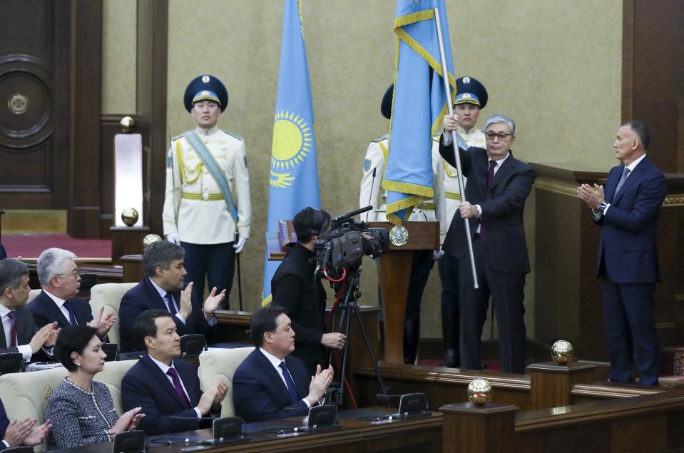 Kazakhstan's interim president Kassym-Jomart Tokayev, second right, holds a national flag during an inauguration ceremony in Astana, Kazakhstan, Wednesday, March 20, 2019. The speaker of Kazakhstan's parliament was sworn as interim president on Wednesday, a day after longtime leader Nursultan Nazarbayev abruptly resigned. (AP Photo)