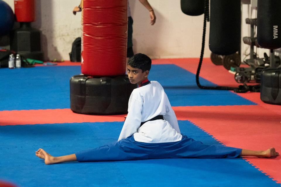 Avinav Prem Anand stretches during taekwondo practice at Polaris Taekwondo.