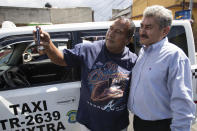Fabio Rodolfo Vasquez, right, poses with a fan at a promotional event outside a coffee shop, on the outskirts of Guatemala City, Saturday, Sept. 19, 2020. Vasquez and his wife, Maria Moreno, entered an online dance contest during the new coronavirus pandemic to help them cope with the recent death of their daughter — and won it. (AP Photo/Moises Castillo)