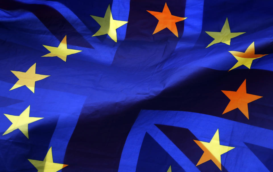 A pro EU protestor waves flags opposite the House of Parliament in London, Thursday, April 4, 2019. Meetings are planned Thursday between the British government and the opposition Labour Party in an urgent search for a compromise solution to the country's departure from the European Union. The upper House of Lords is also set to consider legislation that would force Prime Minister Theresa May to seek a delay from the EU. (AP Photo/Frank Augstein)