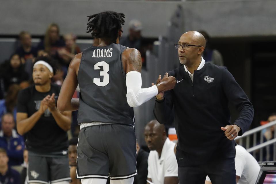 Dec 1, 2021; Auburn, Alabama, USA;  UCF Knights head coach Johnny Dawkins greets forward Isaiah Adams (3) during a timeout in the first half against the Auburn Tigers at Auburn Arena. Mandatory Credit: John Reed-USA TODAY Sports