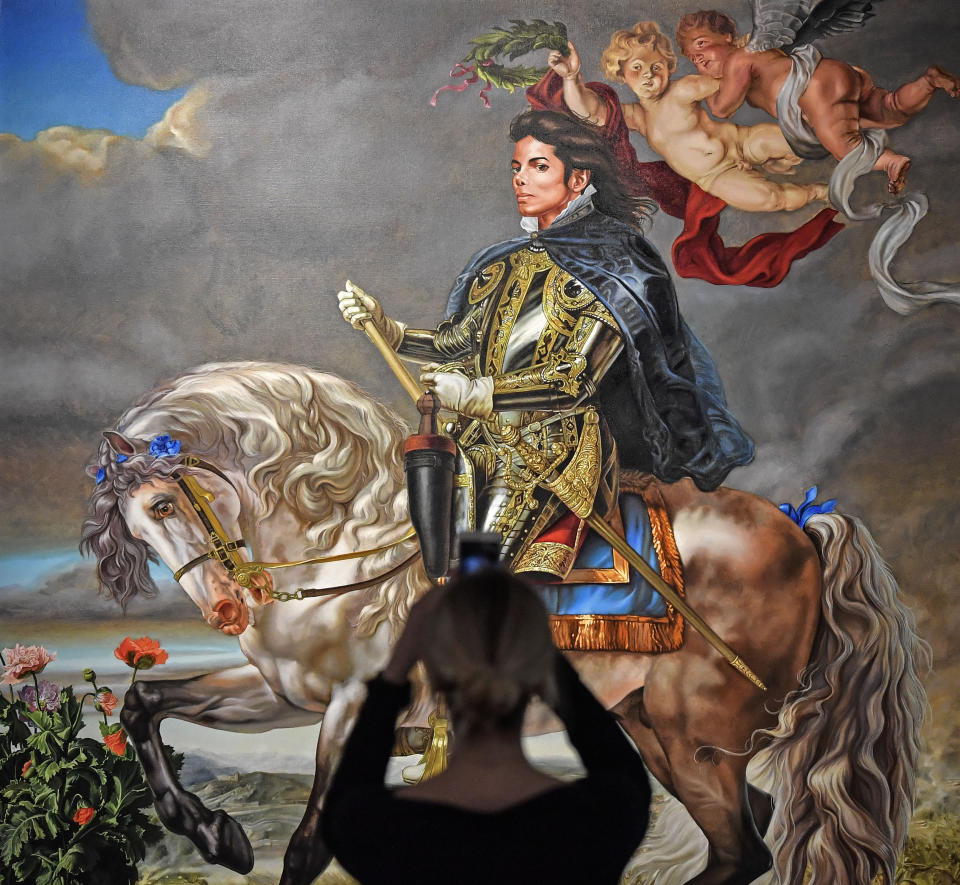 A visitor takes a smartphone picture of the painting 'Equestrian portrait of King Philipp II (Michael Jackson)' from US artist Kehinde Wiley at a preview of the exhibition 'Michael Jackson: On The Wall' at the Bundeskunsthalle museum in Bonn, Germany, Thursday, March 21, 2019. This work is the final commissioned portrait of Michael Jackson. The exhibition around the controversial iconic pop idol is open until July 14. (AP Photo/Martin Meissner)