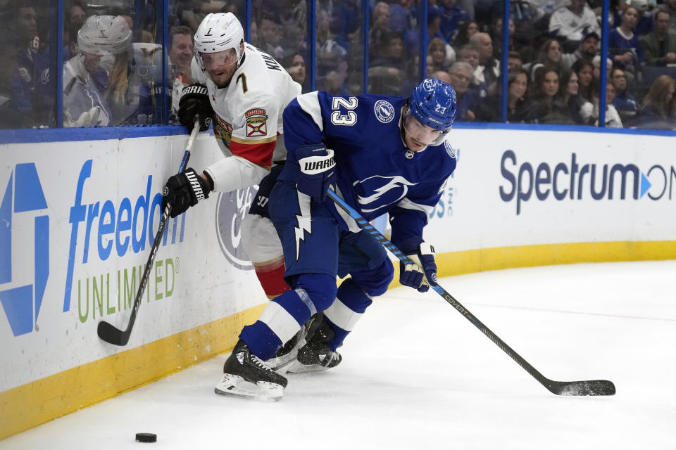 Florida Panthers defenseman Dmitry Kulikov (7) and Tampa Bay Lightning center Michael Eyssimont (23) battle for a loose puck during the second period of an NHL hockey game Wednesday, Dec. 27, 2023, in Tampa, Fla. (AP Photo/Chris O'Meara)