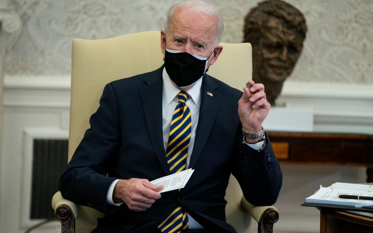 President Joe Biden holds up a microchip during a meeting with lawmakers to discuss U.S. supply chains, in the Oval Office of the White House,  - AP