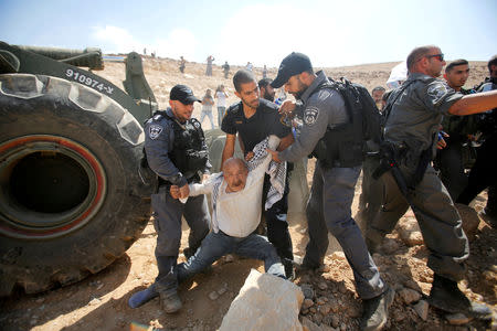 FILE PHOTO: Israeli policemen detain a Palestinian as they protest against Israel's plan to demolish the Palestinian Bedouin village of Khan al-Ahmar, in the occupied West Bank September 14, 2018. REUTERS/Mussa Qawasma/File Photo