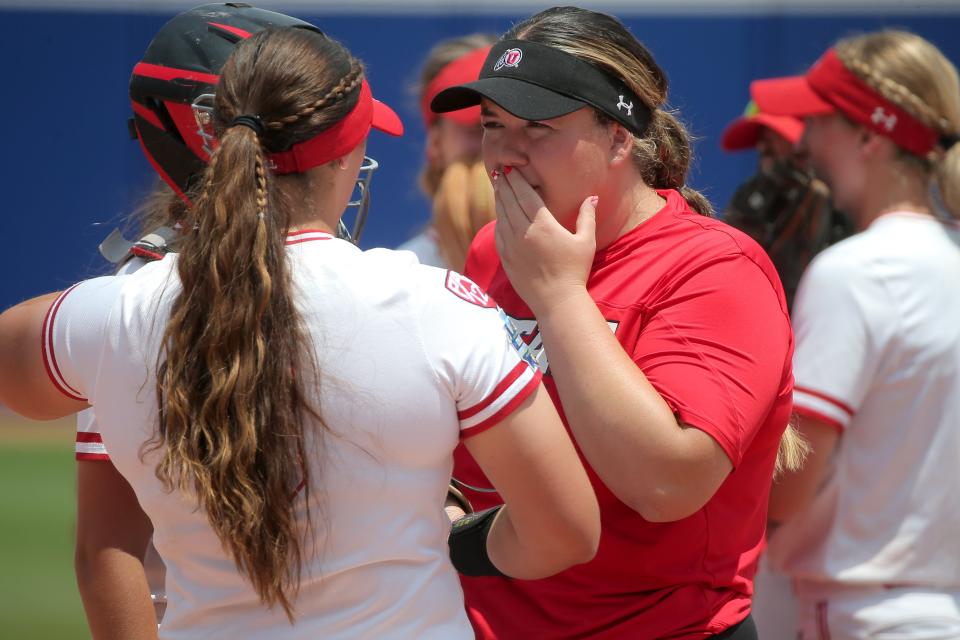 Utah's Paige Parker, facing camera, talks with Mariah Lopez (8) during a softball game between Utah and Washington in the Women's College World Series at USA Softball Hall of Fame Stadium in Oklahoma City, Friday, June 2, 2023. Washington won 4-1.