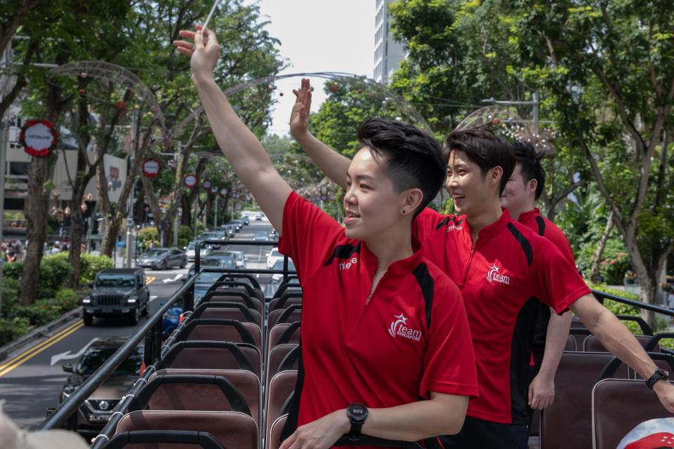 Singapore athletes (from front) Shayna Ng, Loh Kean Yew and Aloysius Yapp wave at their supporters amid their celebratory open-top bus parade. (PHOTO: Sport Singapore)