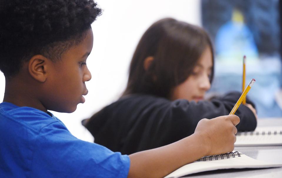 Pfeiffer-Burleigh Elementary School fifth-graders Zhamere Jones, 11, left, and Deiseinia Soto Urvieta, 10, take a test with classmates in Erie last week.