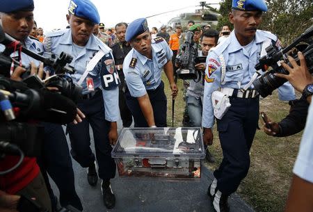 Military policemen carry the flight data recorder of AirAsia QZ8501 at the airbase in Pangkalan Bun, Central Kalimantan January 12, 2015. REUTERS/Darren Whiteside