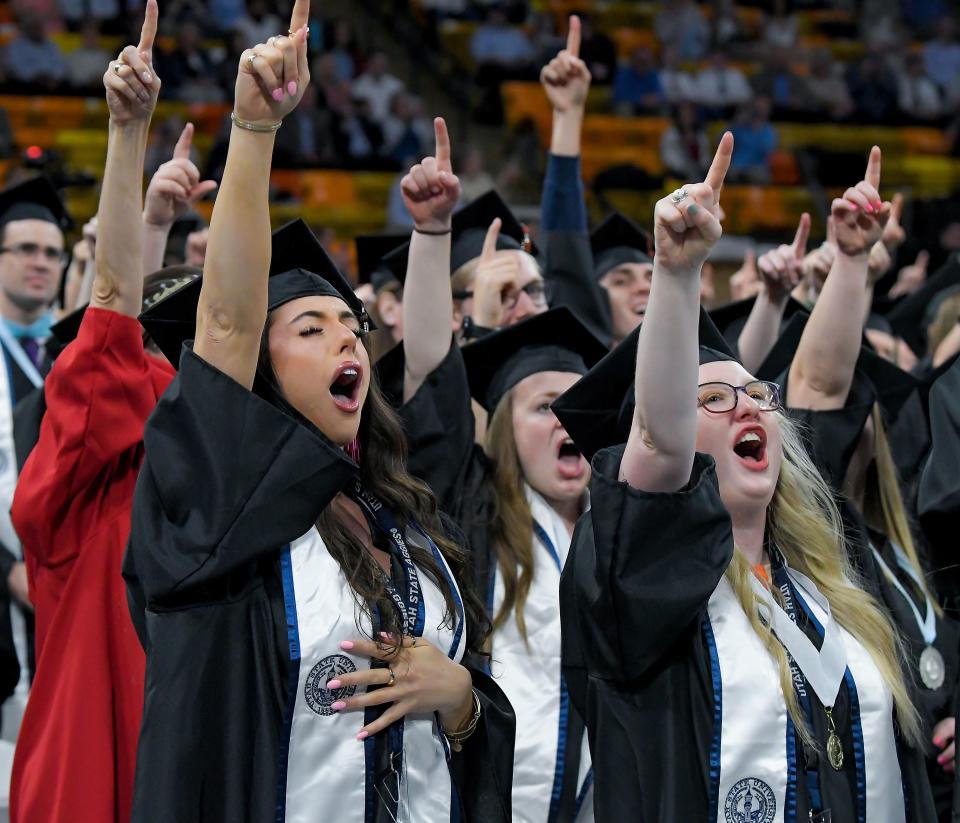 Graduates Erica Evans, left, and Kassie Kunzler celebrate during Utah State University’s commencement ceremony on Thursday, May 4, 2023, in Logan, Utah. | Eli Lucero, Herald Journal