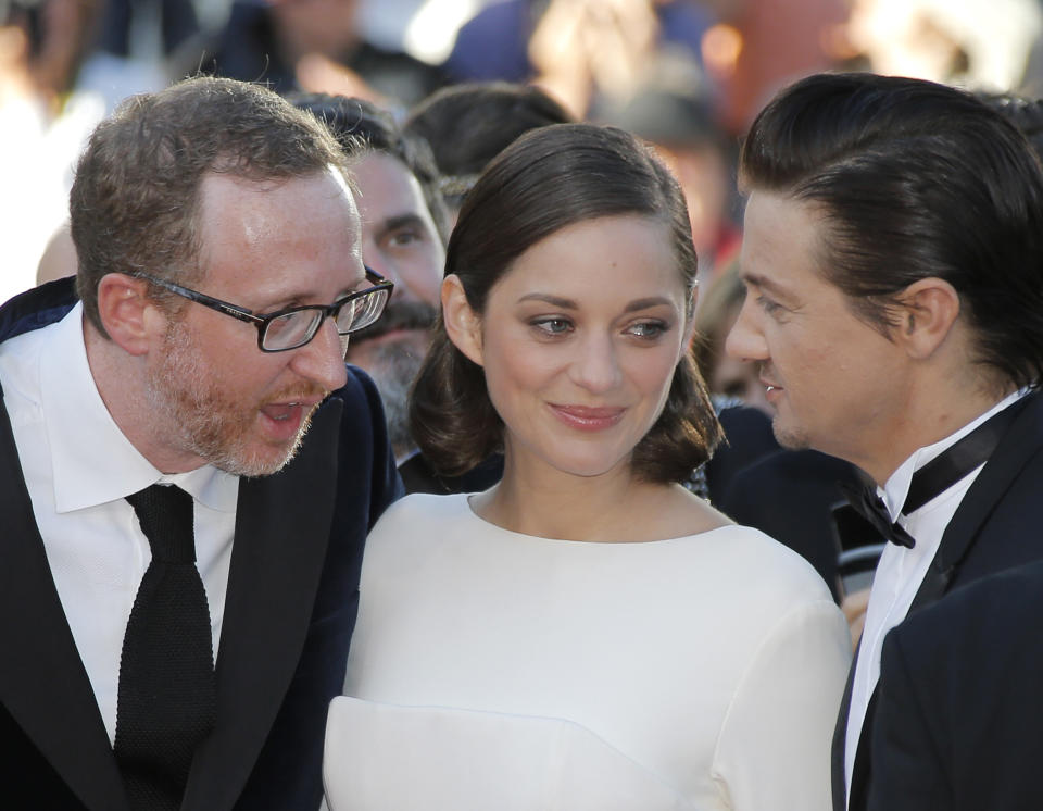 From left, director James Gray, actress Marion Cotillard, and actor Jeremy Renner speak as they arrive for the screening of The Immigrant at the 66th international film festival, in Cannes, southern France, Friday, May 24, 2013. (AP Photo/Lionel Cironneau)