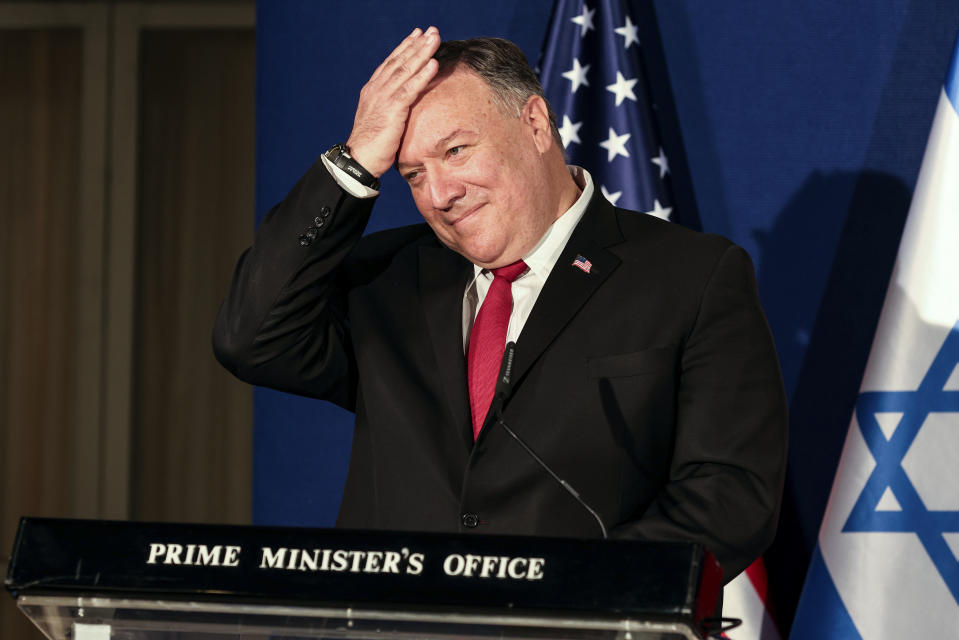 U.S. Secretary of State Mike Pompeo pats his head during a joint press conference with Israeli Prime Minister Benjamin Netanyahu and Bahrain's Foreign Minister Abdullatif bin Rashid Alzayani after their trilateral meeting in Jerusalem on Wednesday, Nov. 18, 2020. (Menahem Kahana/Pool via AP)
