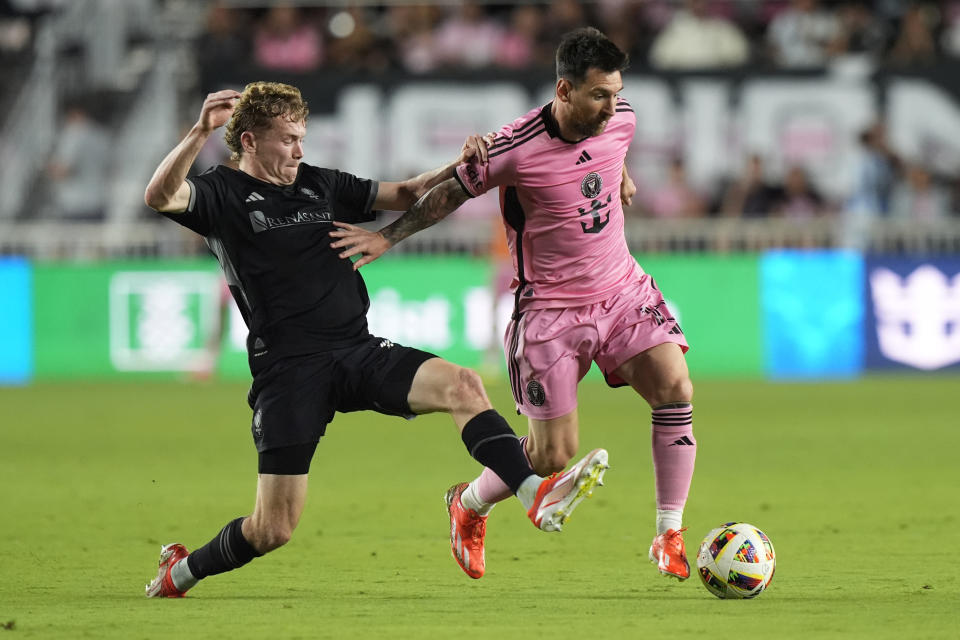 Inter Miami forward Lionel Messi works with the ball as Nashville SC forward Jacob Shaffelburg defends during the first half of an MLS soccer match Saturday, April 20, 2024, in Fort Lauderdale, Fla. (AP Photo/Marta Lavandier)