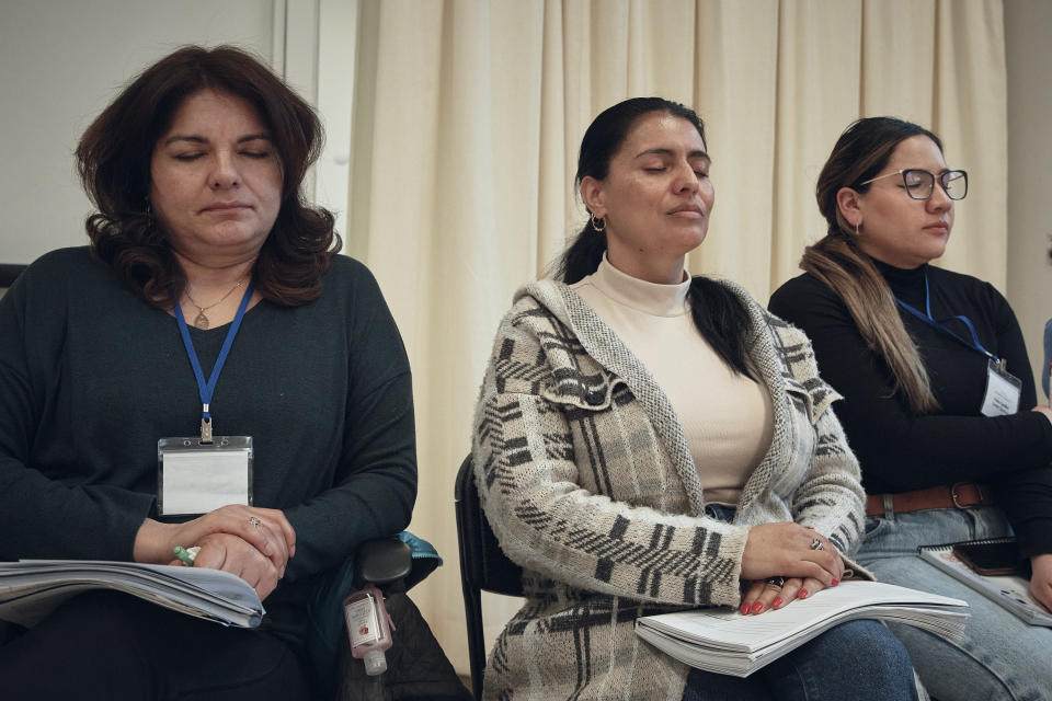 Emma Hernandez, left, Claudia Saenz, center, and Diana Carolina Guillen Quintero close their eyes as they listen to a coach during a sexual harassment prevention class for nannies and housekeepers on Saturday, April 27, 2024, in the Brooklyn borough of New York. Nannies, housekeepers, and home care workers are excluded from many federal workplace protections in the United States, and the private, home-based nature of the work means abuse tends to happen behind closed doors. (AP Photo/Andres Kudacki)