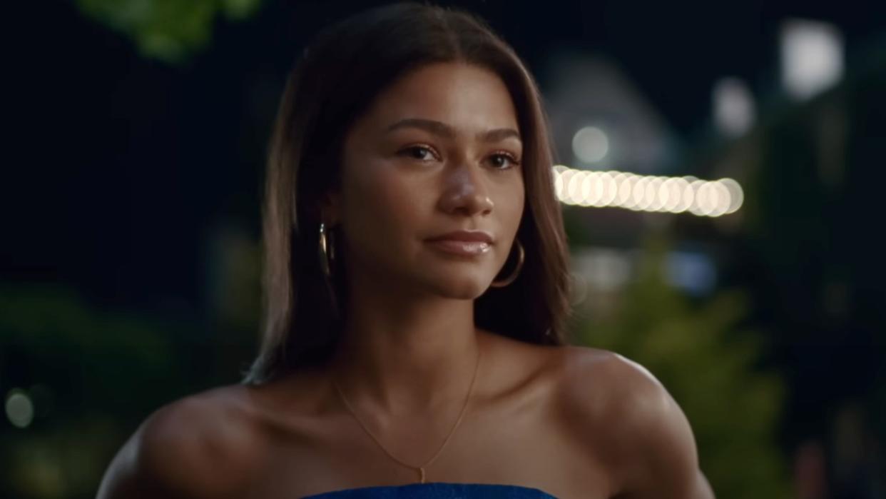  Zendaya looking forward while wearing a strapless blue dress in Challengers. 