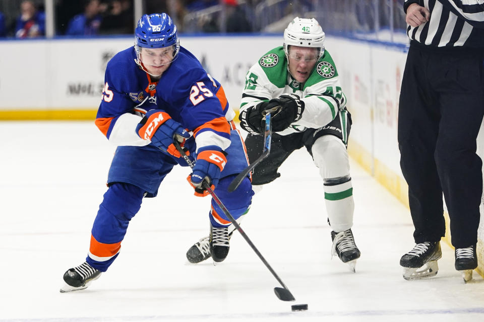 Dallas Stars' Fredrik Olofsson (42) fights for control of the puck with New York Islanders' Sebastian Aho (25) during the second period of an NHL hockey game Tuesday, Jan. 10, 2023, in Elmont, N.Y. (AP Photo/Frank Franklin II)