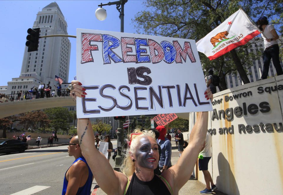 People urging the "reopening" of businesses during the coronavirus pandemic demonstrate in front of City Hall in Los Angeles Friday, May 1, 2020. (AP Photo/Damian Dovarganes)