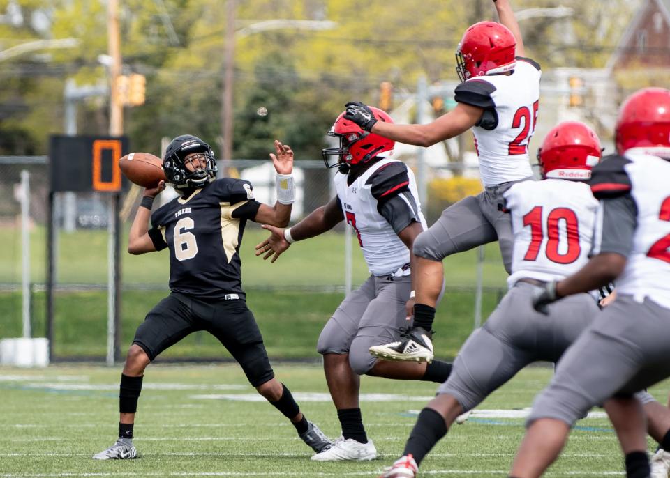 Truman quarterback Rondell Bradley, Jr., left, drops back for a pass against Reading on Saturday, April 10, 2021. The Tigers brought down the Red Knights 54-22.