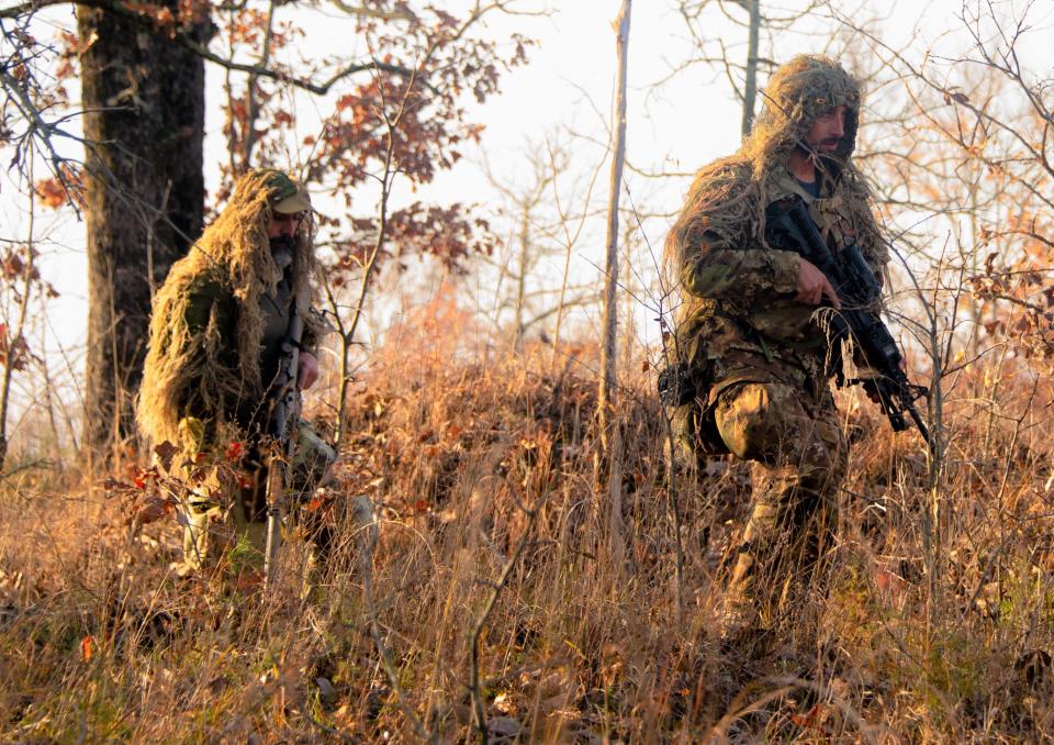 Alessio D’emidio, left, and Alessandro Friscini, right, from Italy, maneuver through the wooded fields of Fort Chaffee during the 2023 international sniper championships. D’emidio and Friscini scour
the woods for items hidden at specific locations.