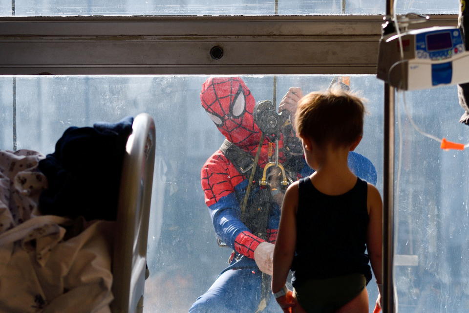 A man dressed as a Spiderman jokes with a child hospitalised in the paediatrics ward of the San Paolo hospital, in Milan, Italy, December 15, 2021. REUTERS/Flavio Lo Scalzo