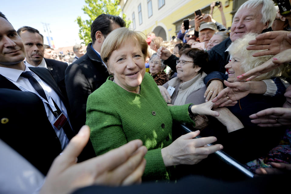 German Chancellor Angela Merkel, center, greets members of the public after a group photo of EU leaders at an EU summit in Sibiu, Romania, Thursday, May 9, 2019. European Union leaders on Thursday start to set out a course for increased political cooperation in the wake of the impending departure of the United Kingdom from the bloc. (AP Photo/Andreea Alexandru)