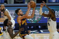 Golden State Warriors guard Stephen Curry, middle, shoots between Minnesota Timberwolves guard Anthony Edwards, left, and forward Jarred Vanderbilt (8) during the second half of an NBA basketball game in San Francisco, Wednesday, Jan. 27, 2021. (AP Photo/Jeff Chiu)