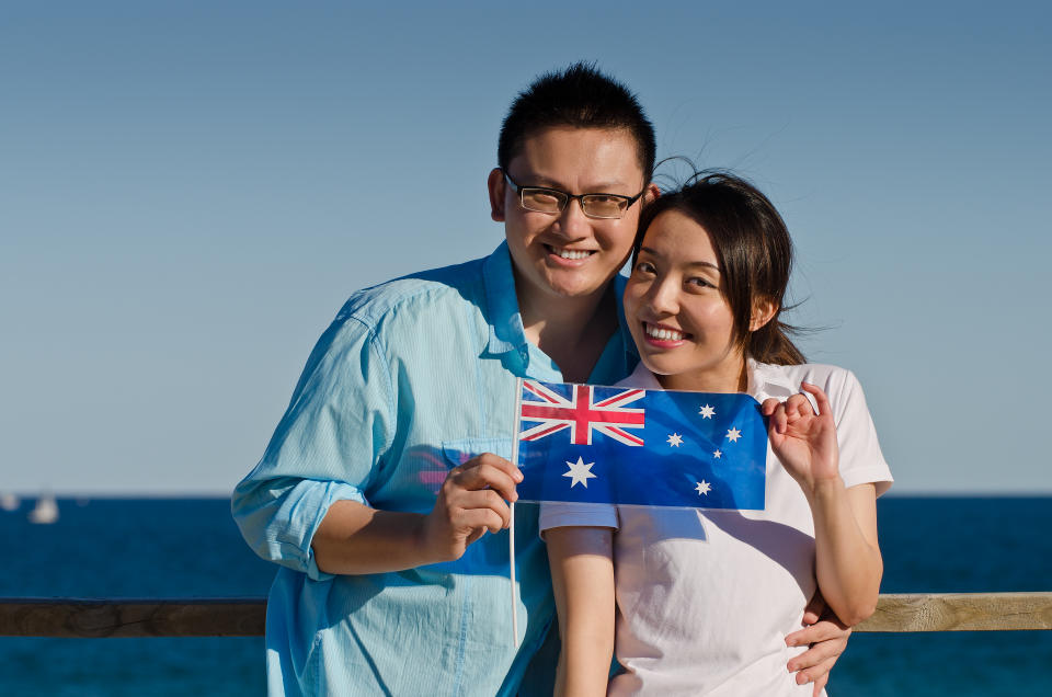 Proud young Australian Asian couple with the flag