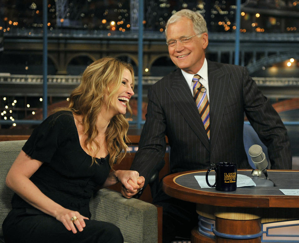 FILE - In this June 9, 2009 file photo released by CBS, actress Julia Roberts laughs as she holds host David Letterman's hand on the set of the "Late Show with David Letterman," in New York. Letterman announced his retirement during a taping on Thursday, April 3, 2014. Although no specific date was announced he told the audience that he will leave his desk sometime in 2015. (AP Photo/CBS, John Paul Filo) MANDATORY CREDIT; NO SALES; NO ARCHIVE; NORTH AMERICAN USE ONLY