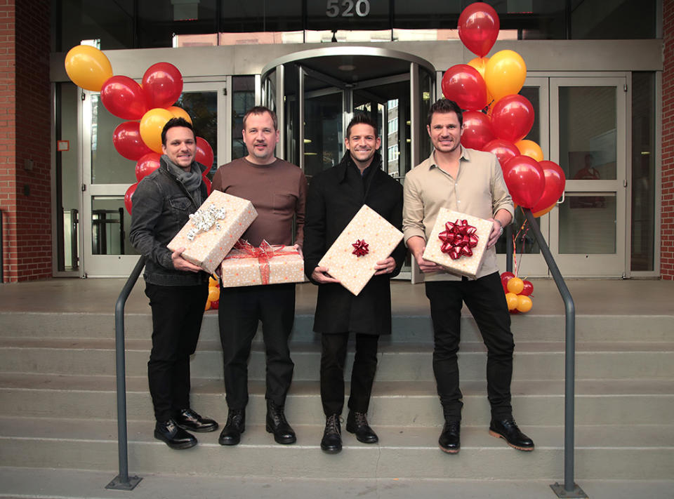 <p>The men of 98 Degrees raised the temperature in chilly NYC on Monday as they surprised Red Cross volunteers at their offices with gifts and a holiday sing-a-long. (Photo: Cindy Ord/Getty Images for Mastercard) </p>