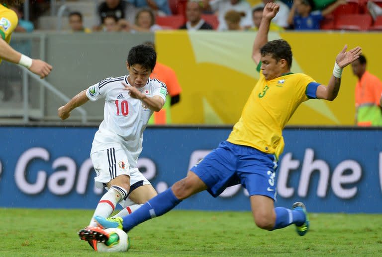 Japan's Shinji Kagawa (L) is denied by Brazil defender Thiago Silva on June 15, 2013