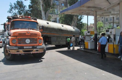 A tanker arrives at a petrol station as Syrians wait for fuel in Damascus. Feared forces led by President Bashar al-Assad's brother used helicopter gunships Sunday in a new assault on rebels in Damascus, activists said, as clashes also raged in Syria's second city Aleppo