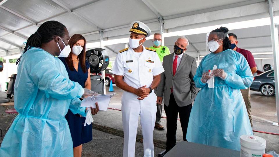 Vice Admiral Jerome Adams, the U.S. Surgeon General, speaks with health workers Gabriel Appoh (L) and Varaiaia Barkus at the COVID-19 drive-thru testing center at Miami-Dade County Auditorium in Miami as the novel coronavirus pandemic continues on Thursday, July 23, 2020.