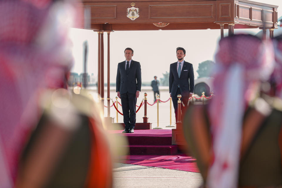 Jordan's Crown Prince Hussein and French President Emmanuel Macron attend a welcome ceremony at the airport in Amman, Jordan, Tuesday, Dec. 20, 2022. Leaders from the Middle East and Europe gathered in Jordan Tuesday in a conference focused on bolstering security and stability in Iraq. (The Royal Hashemite Court via AP)