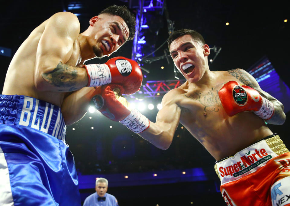 Oscar Valdez (R) punches Adam Lopez during their super featherweight title eliminator fight Saturday at the Cosmopolitan in Las Vegas. (Mikey Williams/Top Rank)