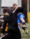 Missouri defensive lineman Michael Sam, left, picks up Andrew Hill as he greets him during pro day for NFL football representatives Thursday, March 20, 2014, in Columbia, Mo. Hill is the son of associate head coach Andy Hill. (AP Photo/L.G. Patterson)
