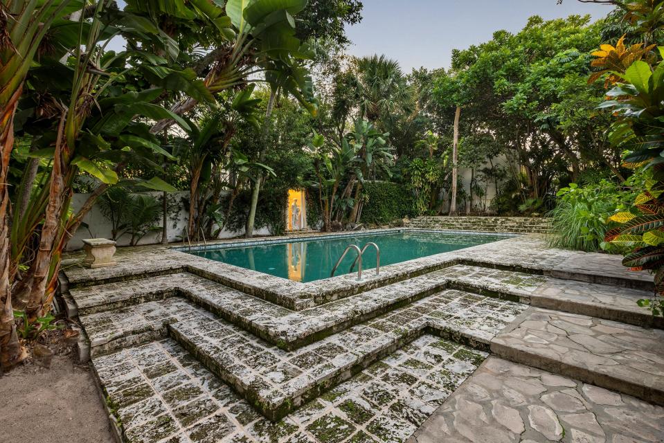 The grotto-like swimming pool is surrounded by stone steps. The statue at the left was on the property when the Cohens bought the landmarked estate in 1987.