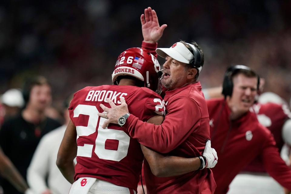 Oklahoma interim coach Bob Stoops celebrates with running back Kennedy Brooks after his touchdown against Oregon.